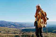 女人旅行者黄色的夹克他背包旅行山生活方式