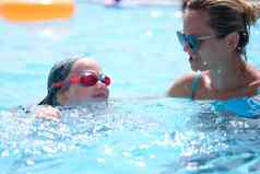 女人教练教学游泳女孩池