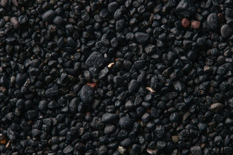 纹理黑色的火山沙子背景黑色的沙子海滩宏摄影特写镜头视图火山沙子表面冰岛黑色的沙子宏摄影黑色的卵石背景