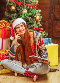 美丽的女人冬天针织毛衣他条纹袜子坐在地板上交叉腿桩礼物圣诞节树特写镜头