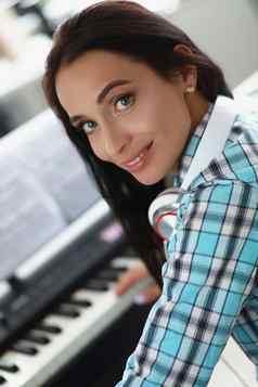 女玩白色黑色的键盘计划美丽的有创意的音乐家