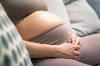 怀孕了女人肚子怀孕概念怀孕了肚子关闭细节怀孕了女人放松舒适的沙发首页