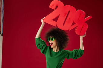 美时尚女人卷曲的发型绿色衣服二十百分比折扣红色的背景不变的
