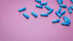 前视图胶囊药片粉红色的背景处方药物蓝色的胶囊药片制药行业药药理学药物发展药物研究胶囊药片行业
