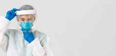 科维德冠状病毒疾病医疗保健工人概念自信严肃的表情女亚洲医生把脸盾呼吸器个人保护设备白色背景