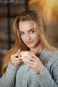 肖像年轻的美丽的女人坐着现代咖啡馆酒吧室内杯咖啡