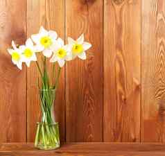 花束新鲜的花水仙花花瓶木表格相反棕色（的）木墙