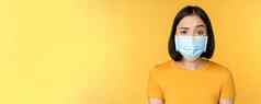 肖像持怀疑态度困惑亚洲女人医疗脸面具提高眉怀疑站黄色的背景