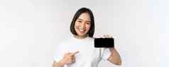 肖像微笑朝鲜文女人指出手指移动电话屏幕显示水平智能手机显示推荐网站商店在线白色背景