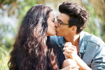 分享亲密的吻可爱的年轻的夫妇坐着分享浪漫的吻