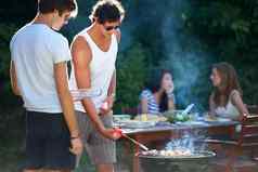 烧烤肉完美年轻的人烧烤肉烧烤在户外生活方式