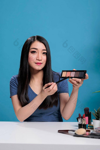 肖像有吸引力的亚洲影响者回顾化妆品调色板