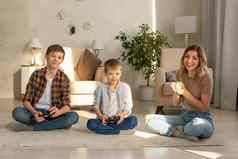 肖像男孩快乐女人坐在地板上房间玩视频游戏操纵 杆