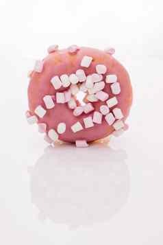 色彩斑斓的磨砂粉红色的甜甜圈美味的旋转甜甜圈白色背景特写镜头拍摄粉红色的美味的美味的甜蜜的甜甜圈色彩斑斓的洒白色背景甜点
