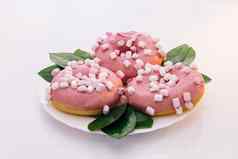 色彩斑斓的磨砂粉红色的甜甜圈各种各样的甜甜圈粉红色的上釉洒甜甜圈旋转拍摄白色美味的美味的甜蜜的甜甜圈色彩斑斓的洒白色背景甜点
