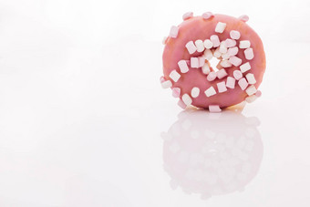 美味的旋转甜甜圈白色背景特写镜头拍摄粉红色的美味的美味的甜蜜的甜甜圈色彩斑斓的洒白色背景甜点色彩斑斓的磨砂粉红色的甜甜圈