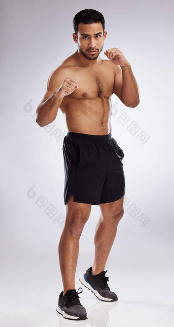 <strong>遵</strong>循的决心拍摄年轻的男人。练习拳工作室背景