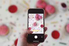 采取照片食物色彩斑斓的喝粉红色的上釉甜甜圈白色表格模糊背景平铺前视图