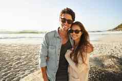 享受海微风太阳拍摄美丽的年轻的夫妇站一边一边海滩