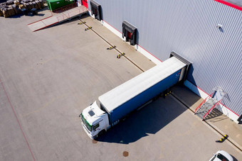 空中拍摄卡车附加半预告片离开工业仓库存储建筑加载区域卡车负载卸载商品