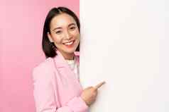 图像亚洲女企业家西装指出手指董事会显示smth白色墙展示图表信息站粉红色的工作室背景