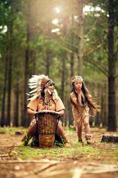 有趣的自然拍摄年轻的女人敲鼓玩dressup女儿森林