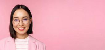 关闭肖像亚洲企业女人专业女商人眼镜微笑自信相机粉红色的背景