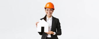 微笑好看的女亚洲女售货员建设公司销售房屋穿头盔业务西装显示模型舒适的首页站白色背景