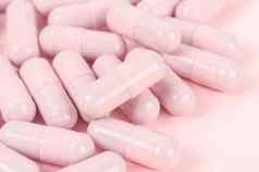 粉红色的胶囊药片粉红色的背景