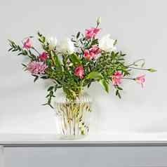 简约花束白色郁金香粉红色的eustoma风信子桉树槽玻璃花瓶白色面板人工壁炉