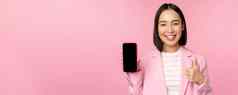 满意微笑亚洲女商人推荐移动电话应用程序网站公司智能手机显示屏幕拇指粉红色的背景