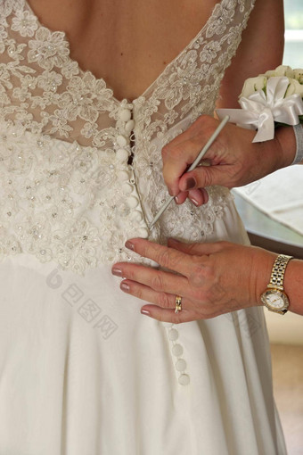 关闭手最后钉纽扣新娘的婚礼衣服