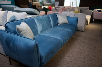 美丽的极简主义时尚的蓝色的丝绒沙发光灰色的枕头显示出售家具商店展厅生活房间家具时尚的现代舒适的软垫家具