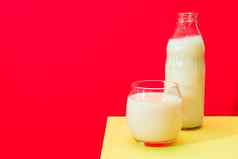 玻璃瓶大玻璃牛奶黄色的表格红色的背景