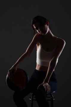 十几岁的女孩篮球一边基斯工作室肖像黑暗背景