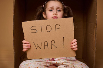 高加索人孩子首页衣服坐在内部纸板盒子停止战争海报概念难民移民失去了房屋政治军事冲突国家