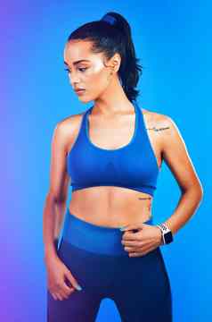 健身状态心工作室拍摄有吸引力的年轻的女运动员摆姿势蓝色的背景