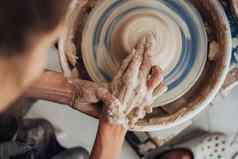 前视图女陶器主工作粘土工作室手工制作的过程创建能轮