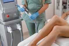 专业美容师给激光拔毛治疗女腿
