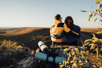 回来视图旅行者夫妇拥抱坐着边缘山日落旅行夫妇享受徒步旅行旅行前山