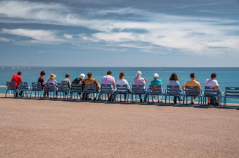 人坐著名的蓝色的椅子路堤不错的法国看Azure水利古里亚海宁静年龄休息年龄上了年纪的人地平线社会