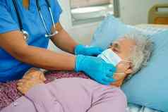 医生检查亚洲老高级女人病人穿面具保护科维德冠状病毒