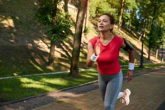 女跑步者享受早....慢跑城市公园美丽的夏天一天
