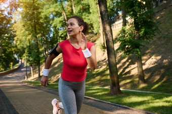 惊人的有吸引力的中间岁的适合女人女运动员运动员跑步者慢跑者运行城市公园健身有氧运动锻炼概念
