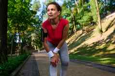 女运动员持有膝盖手疼痛肌肉受伤锻炼跑步机概念体育受伤医疗保健运动员运行户外痛苦腿疼痛