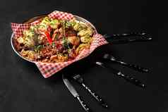 各种各样的美味的烤肉蔬菜烧烤酱汁铁托盘黑色的背景关闭大集热肉菜前视图