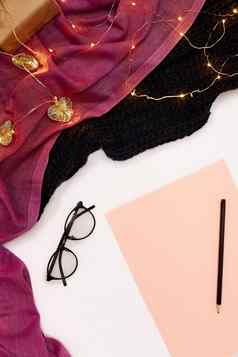 黑色的眼镜粉红色的纸年目标围巾圣诞节灯白色背景