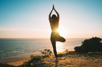 女人练习瑜伽二分法山海洋视图日落年轻的女人站弗尔克萨萨纳锻炼树构成户外自然