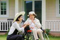上了年纪的女人放松轮椅后院女儿