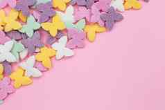 色彩斑斓的蝴蝶受欢迎的糖糖果一流的谎言粉红色的背景对角左角落里